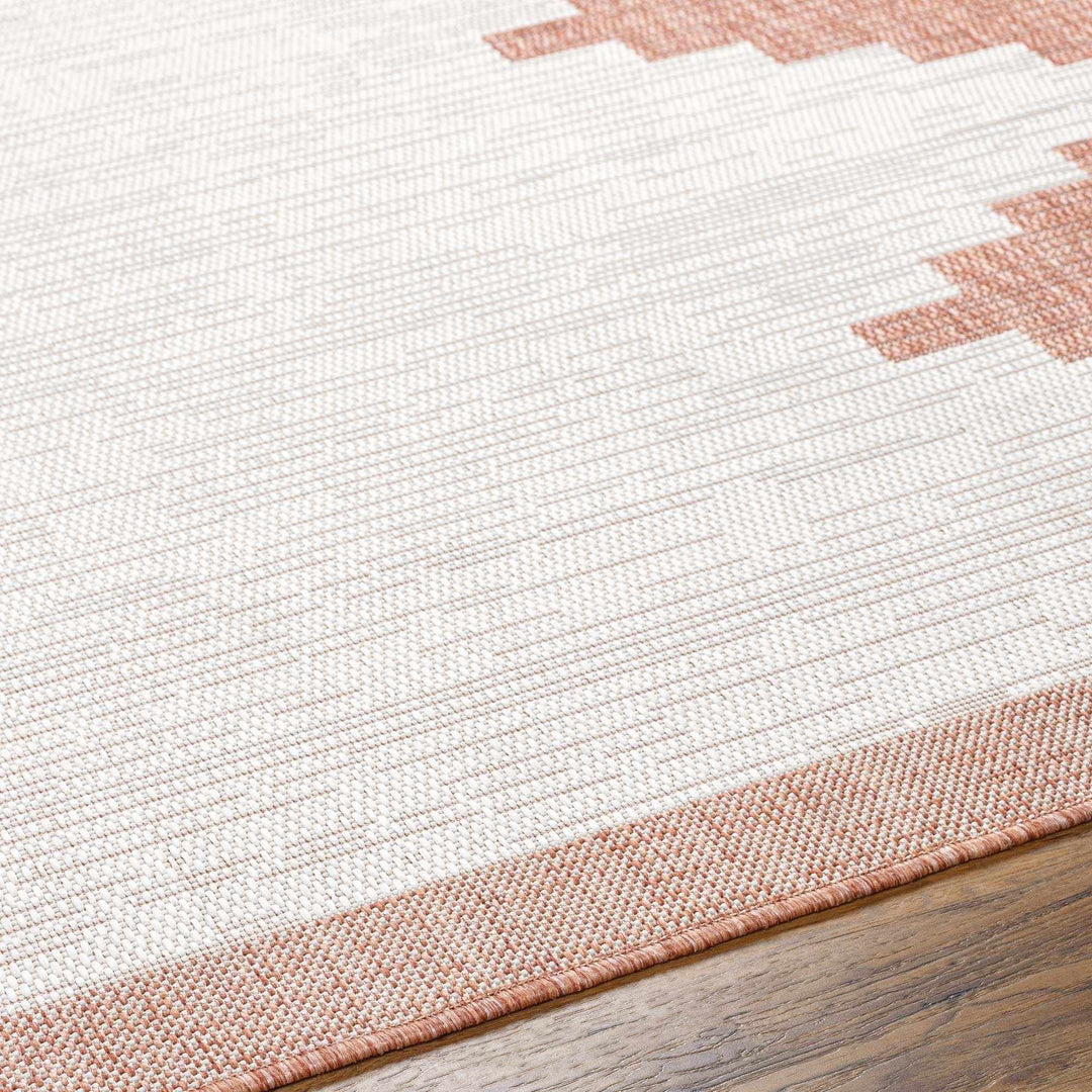 Close-up of a white and pink woven rug on a wooden floor.

Djugun Peach Fuzz Indoor & Outdoor Area Rug