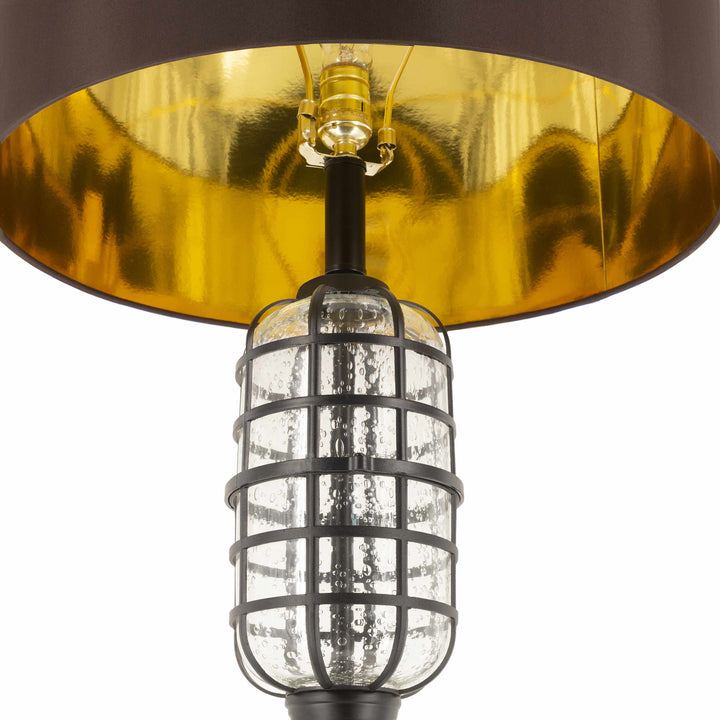 Close-up of a lamp with a gold shade and clear glass cage on a white background

Binuatan Floor Lamp