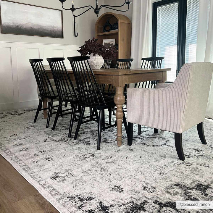 Dining room with wooden table and black chairs on a patterned rug.

Bodrum Gray Area Rug