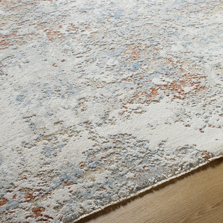 Textured area rug with a neutral color palette on a wooden floor.

Dinos Luxe Rug