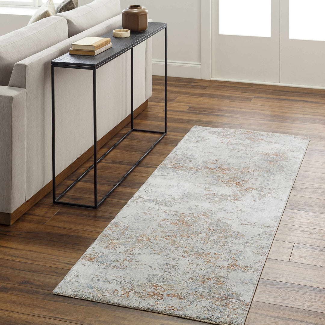 Long rectangular rug on a wooden floor in a living room setting with a side table.

Dinos Luxe Rug