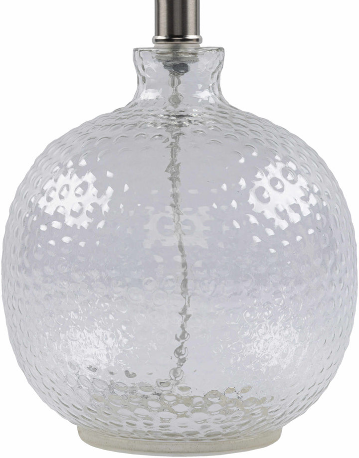 Clear glass lamp with textured surface on a white background

Enetai Glass White Table Lamp