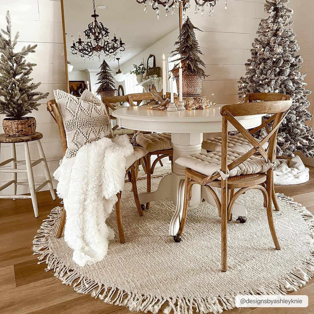Dining room with wooden chairs, a round rug, and Christmas trees.

Iantha Jute Rug