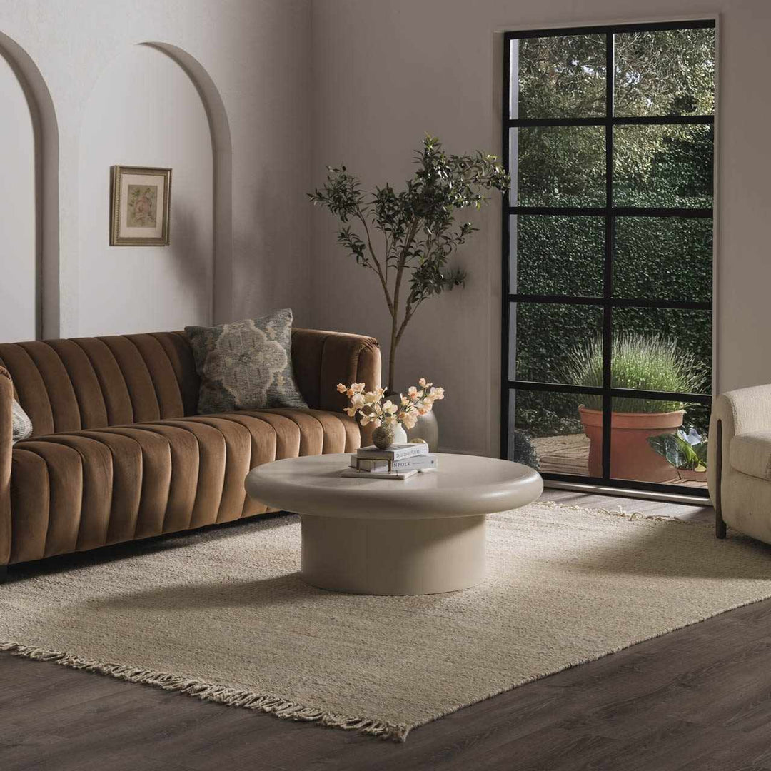 Modern living room with brown sofa, round coffee table, and decorative elements.

Iantha Jute Rug