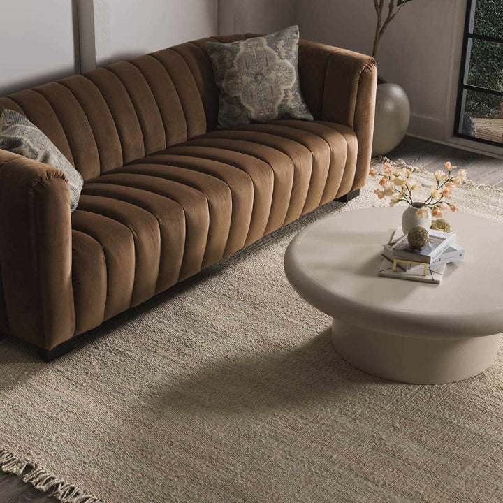 Brown sofa in a living room with a round coffee table and decorative items.

Iantha Jute Rug