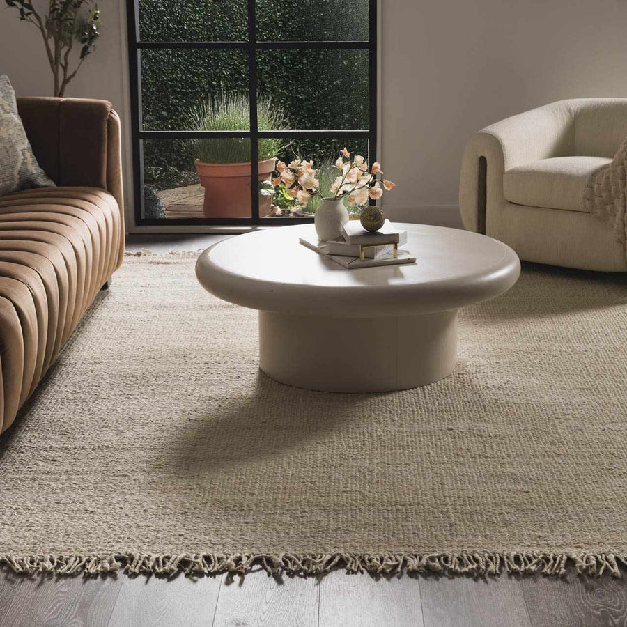 Living room with a round coffee table, beige sofa, and decorative elements.

Iantha Jute Rug