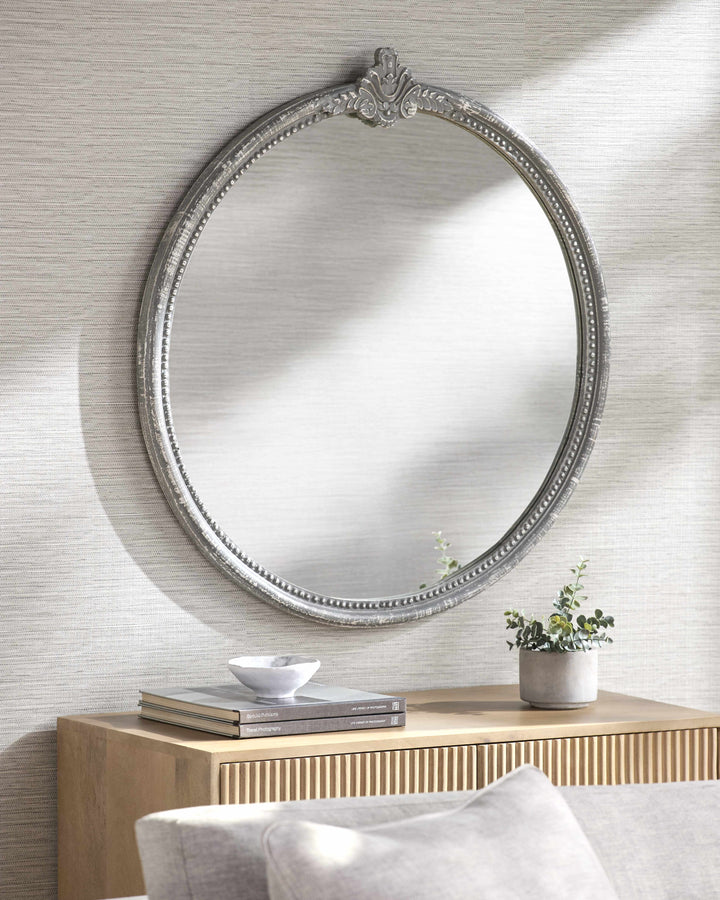 Decorative round mirror with ornate frame on a wall above a wooden console table.

Kandersteg Gray Accent Mirror