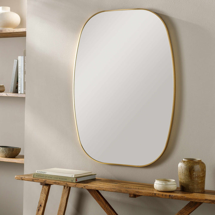 Large oval mirror with gold frame on a neutral wall above a wooden console table.

Kopparberg Gold Frame Round Mirror