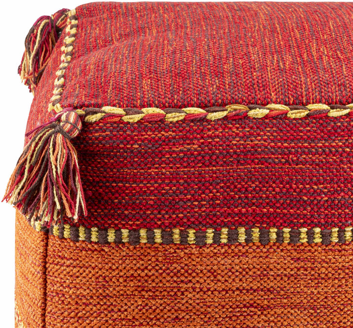 Close-up of a red and orange woven ottoman with decorative stitching and tassels.
Mainaguri Pouf