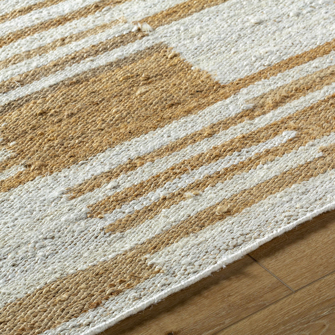 Close-up of a textured rug with brown and beige stripes on a wooden floor.