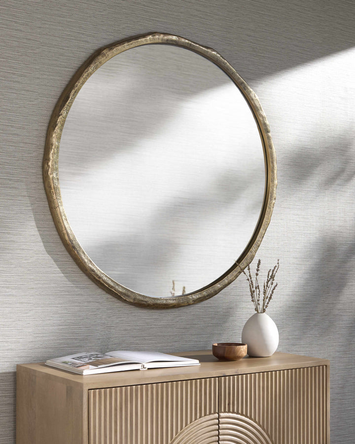 Round mirror with gold frame on a textured wall above a wooden console table.

Vallelado Gold Accent Mirror