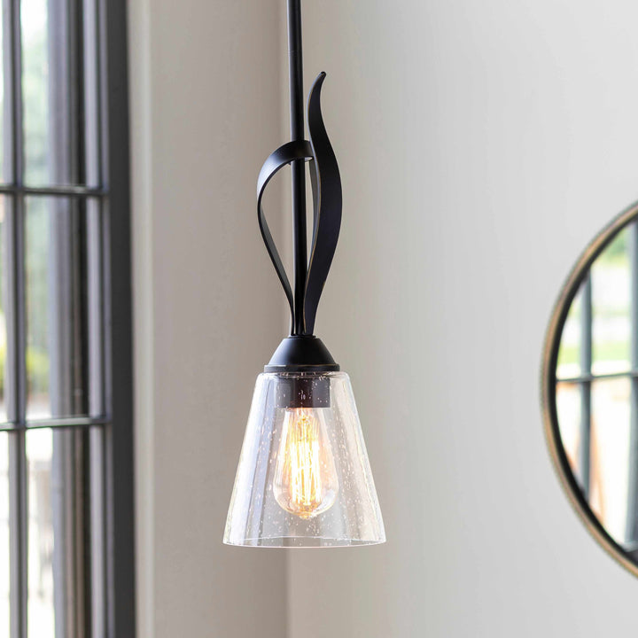 Pendant light with black fixture and clear glass shade on a neutral wall.

Collinswood Ceiling Light