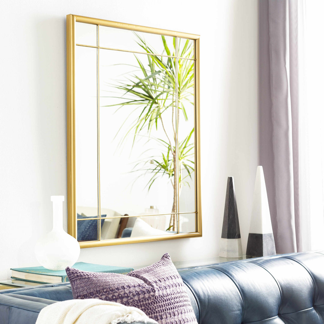 Gold-framed mirror on a wall above a blue sofa with decorative pillows.

Doyong Mirror