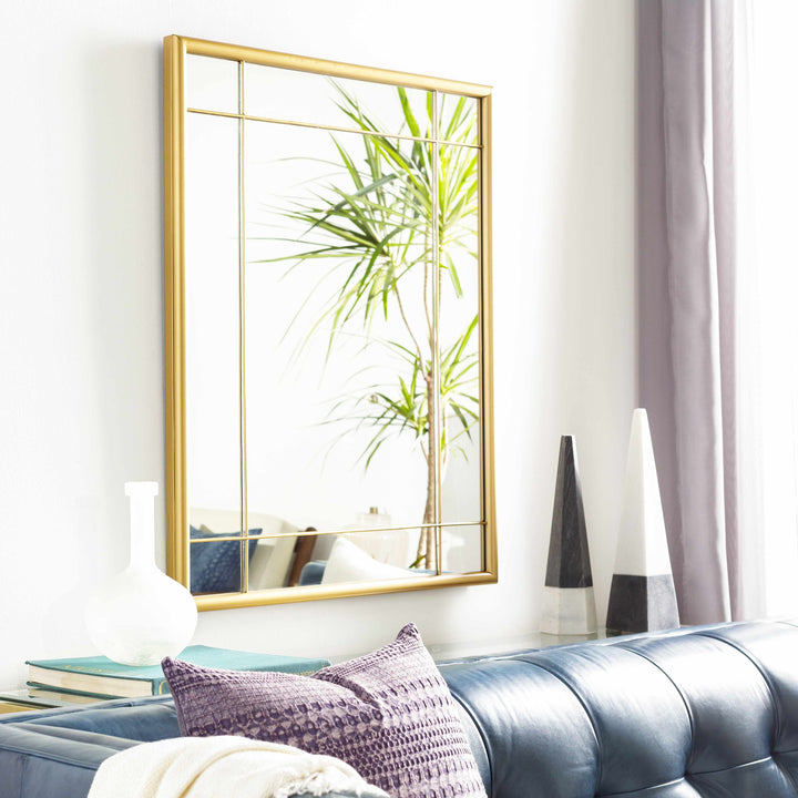 Gold-framed mirror on a wall above a blue sofa with decorative pillows.

Doyong Mirror