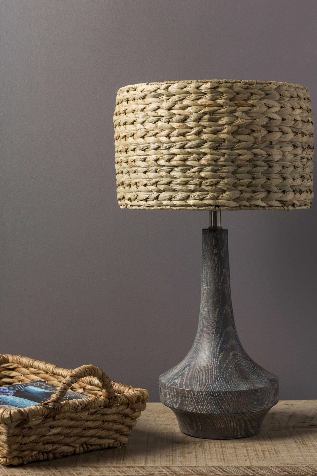 Table lamp with woven shade and textured base on a wooden surface against a gray background

Kabankalan Seagrass Resin Table Lamp