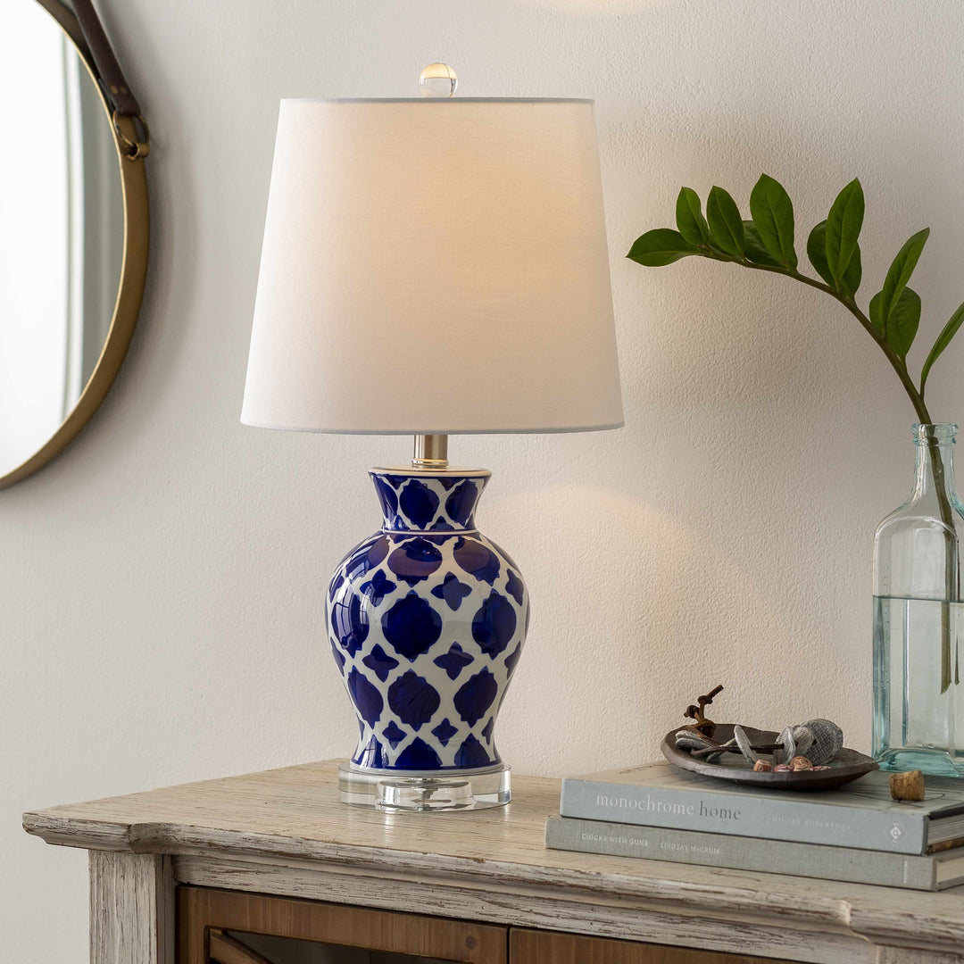 Blue and white patterned lamp on a wooden table with books and a plant.

Pangian White & Blue Patterned Ceramic Table Lamp
