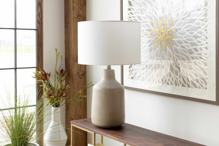 White lamp on a wooden console table with decorative elements in a room.

Quezon Beige Resin Table Lamp