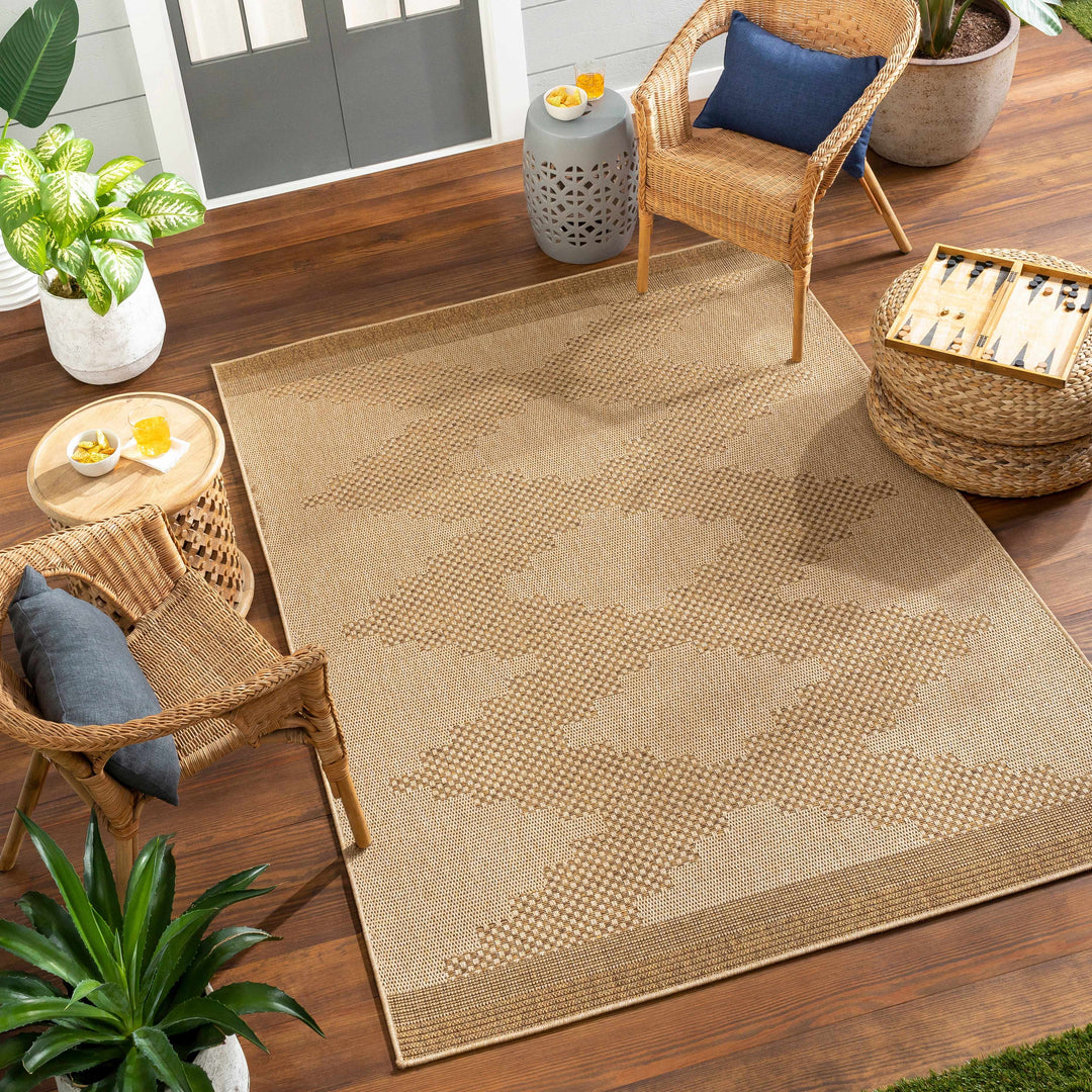 Beige outdoor rug on a wooden patio with wicker furniture and plants.

Colum Flatweave Faux Jute Rug